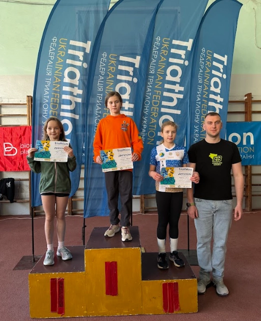 Спортсмени на п'єдесталі пошани з нагородами після змагань з акватлону в Хмельницькому