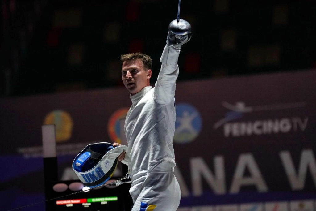 Шпажист у білому костюмі піднімає руку з рапірою, святкуючи перемогу на змаганнях в Астані