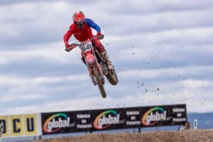 Мотокрос на трасі Circuito Las Arenas, гонщик у червоній формі на мотоциклі в стрибку