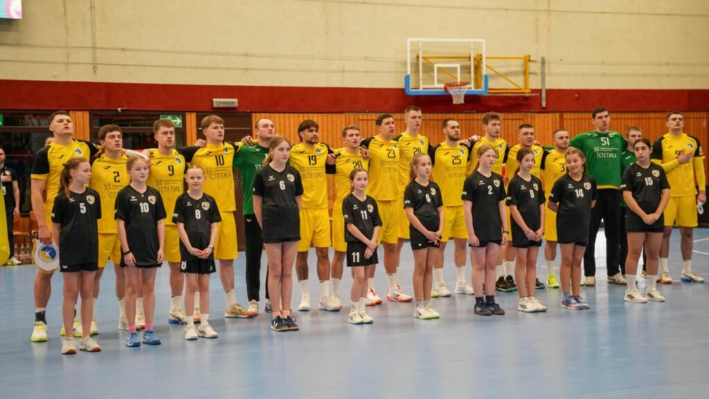 Українська збірна з гандболу в жовтій формі стоїть на майданчику перед матчем зі Словаччиною