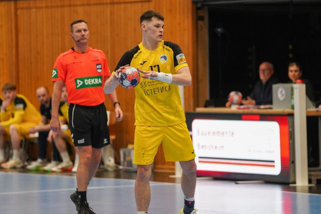 Український гандболіст у жовтій формі готується до кидка під час матчу проти Словаччини