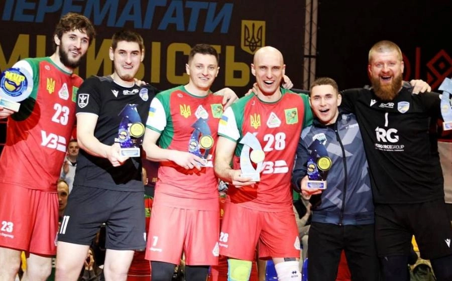 Волейбольна команда святкує перемогу з трофеями на чемпіонаті, гравці усміхнені та радісні