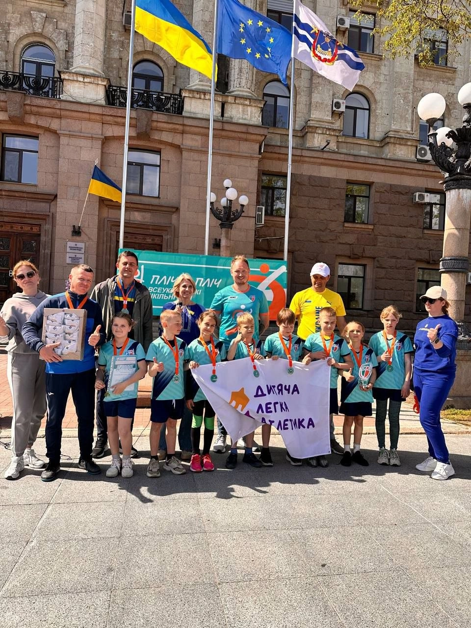 Учасники Всеукраїнських шкільних ліг "Пліч-о-пліч" у Миколаєві з прапором "Дитяча легка атлетика