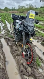 Мотоцикл учасника змагань Cross-Country Rally (GPX) у бруді під час дощового другого дня ралі