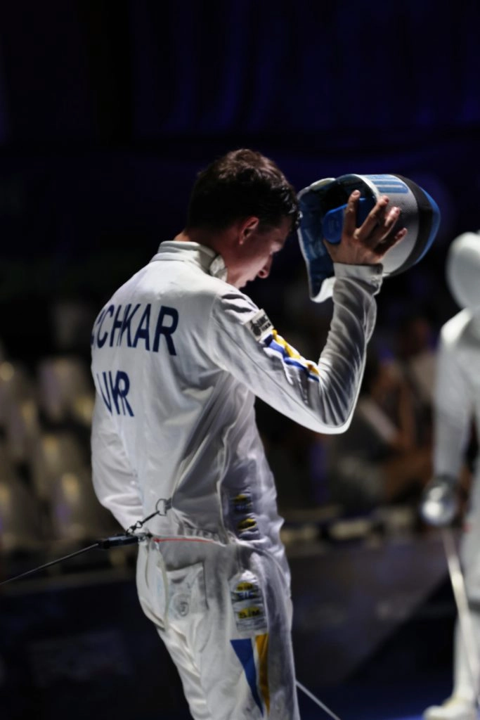Фехтувальник Роман Свічкар знімає маску після бою на чемпіонаті Європи в Антоні 2023
