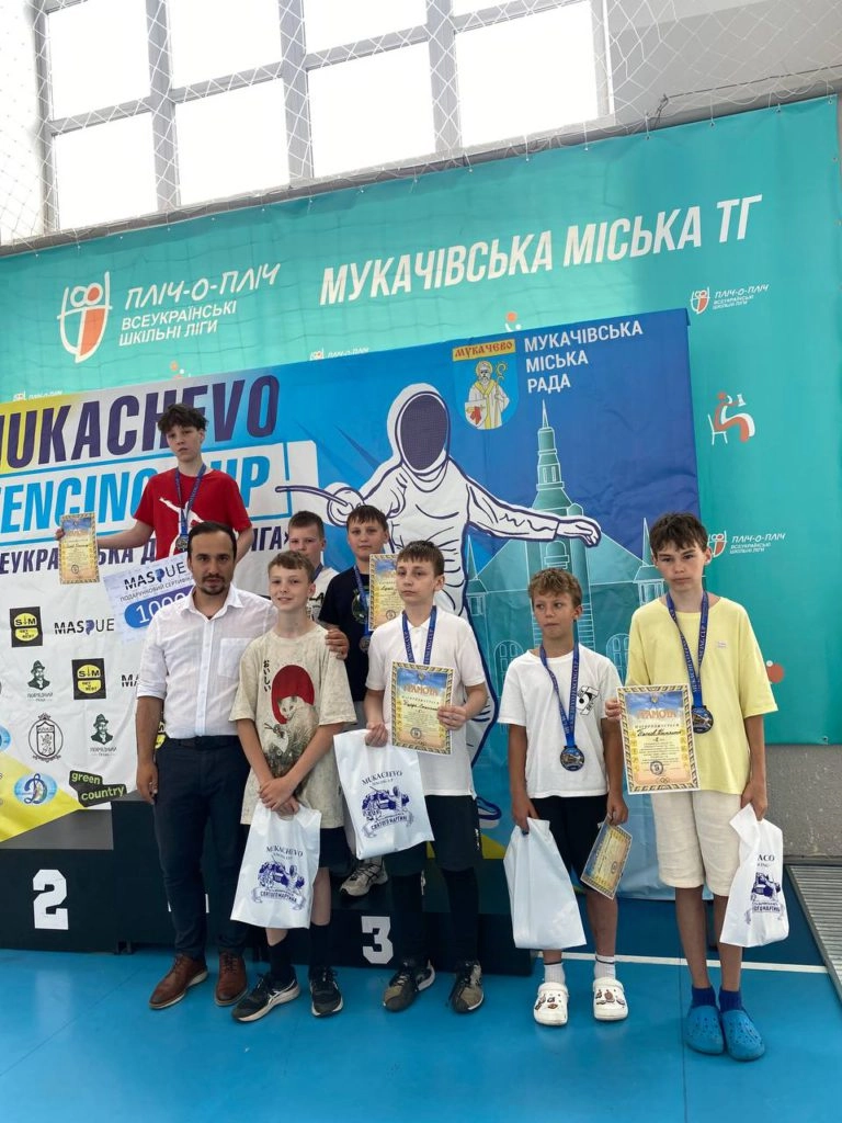 Юні переможці Mukachevo Fencing Cup-2026 з нагородами на фоні банера змагань у Мукачеві